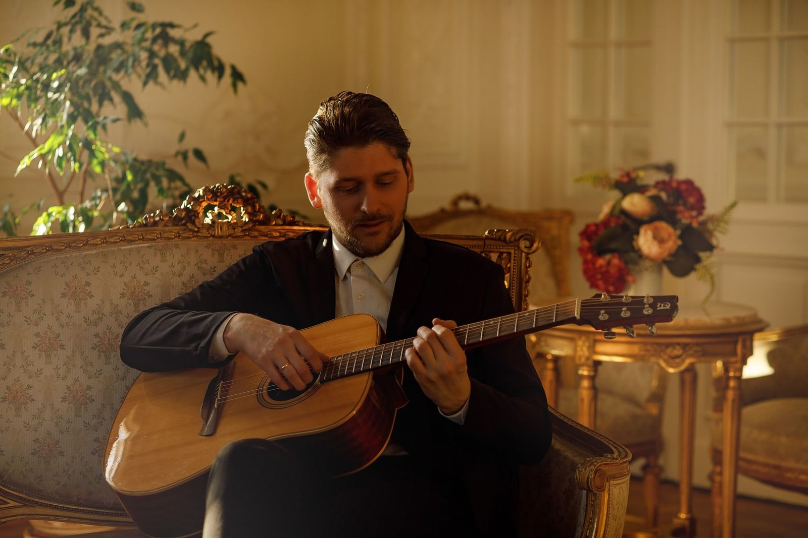 Justinas Stanislovaitis groja gitara jaukioje dvaro salėje