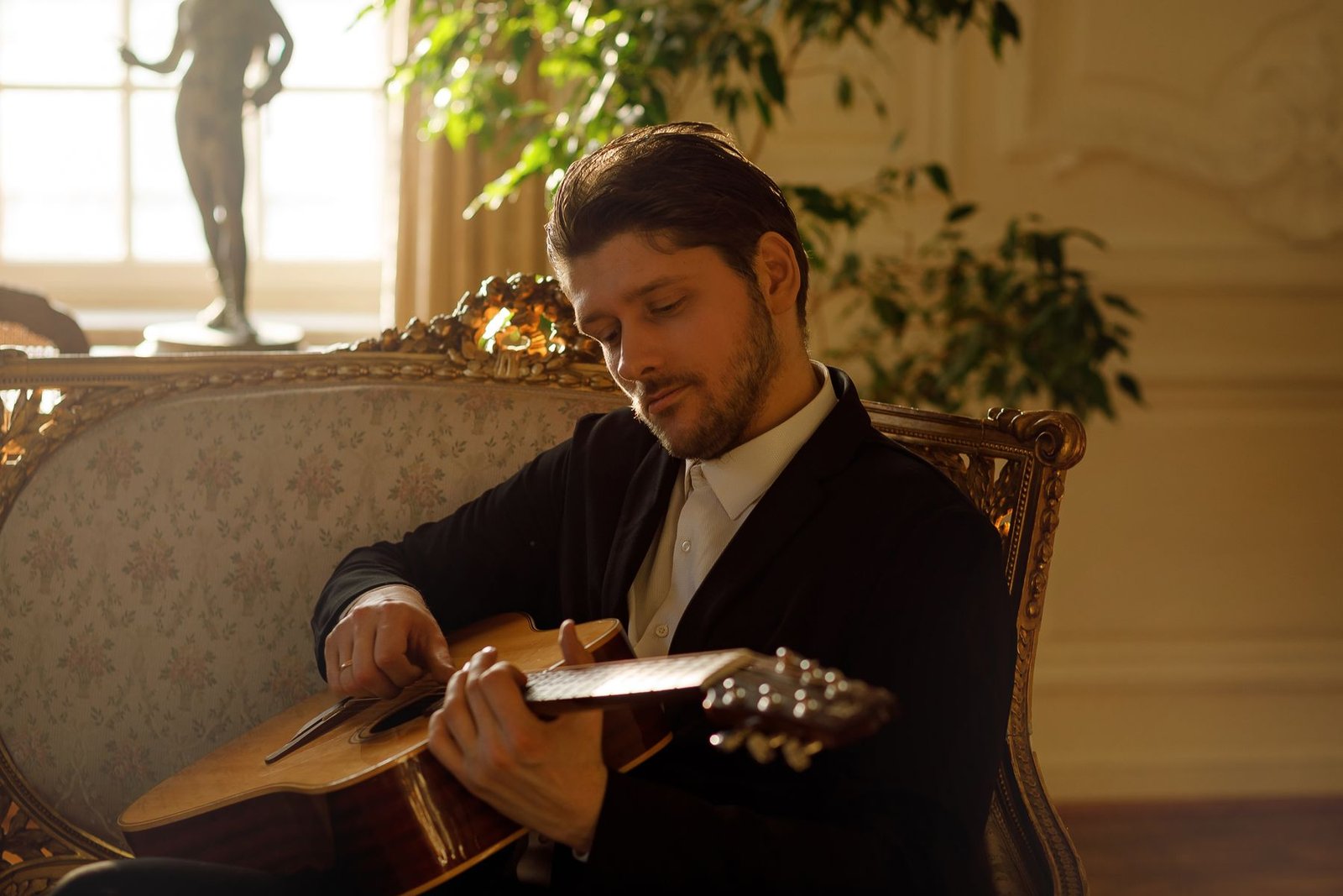 Justinas Stanislovaitis groja gitara dvaro interjere